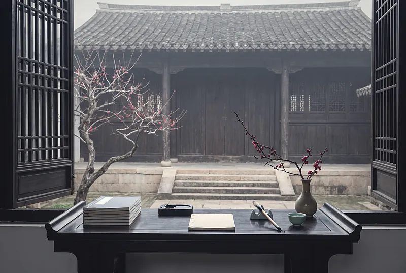 A scholar's desk with books and ink in a quiet old Chinese academy courtyard, with winter plum blossom