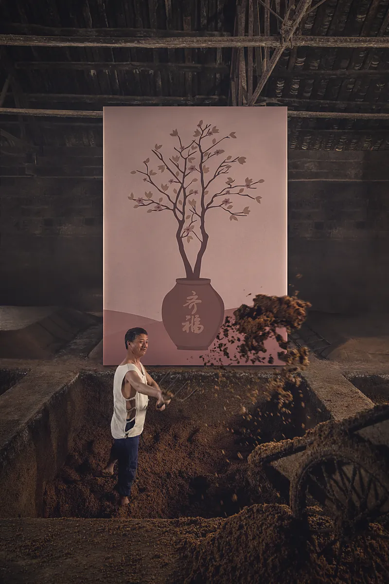 A distiller in the pit lifting out fermented grain; the painted tree behind him is in blossom