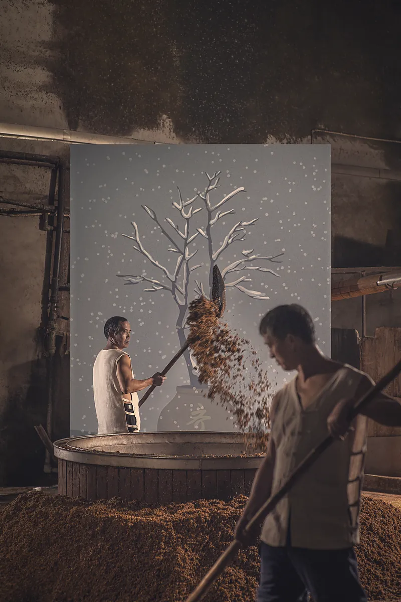 Distillers tossing steamed grain to cool; the painted tree behind them is covered in snow