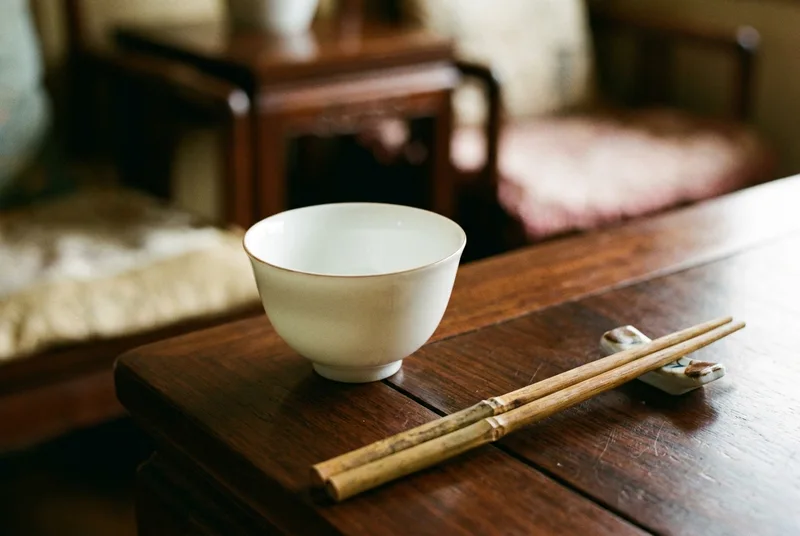 深色木桌上的精致白瓷小酒杯细节